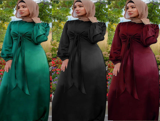 Three dresses in green, black, and maroon with a hijab against a natural background.